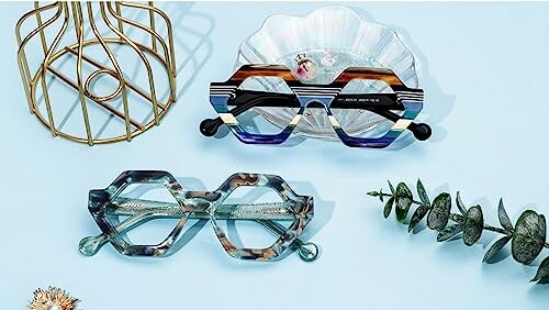 Geometric eyeglasses with decorative elements on a blue surface.